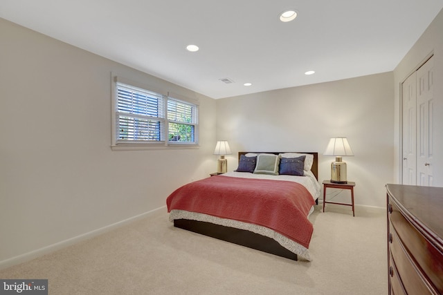 bedroom featuring baseboards, visible vents, and light colored carpet