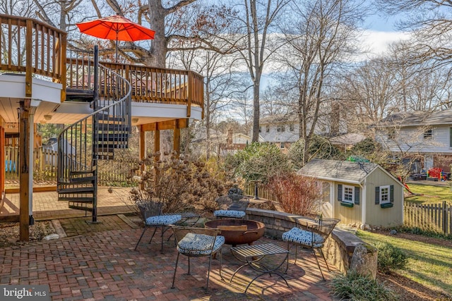 view of patio / terrace with a wooden deck, stairs, fence, and an outdoor structure