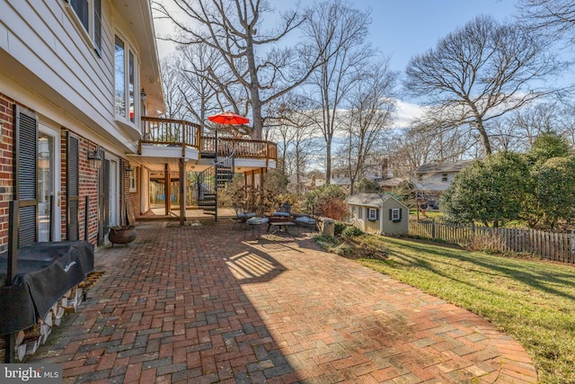 view of patio / terrace with area for grilling, stairway, fence, a wooden deck, and an outdoor structure