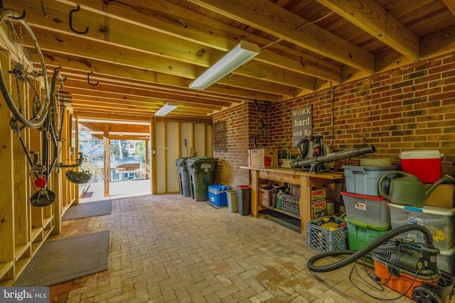 below grade area featuring brick floor and brick wall