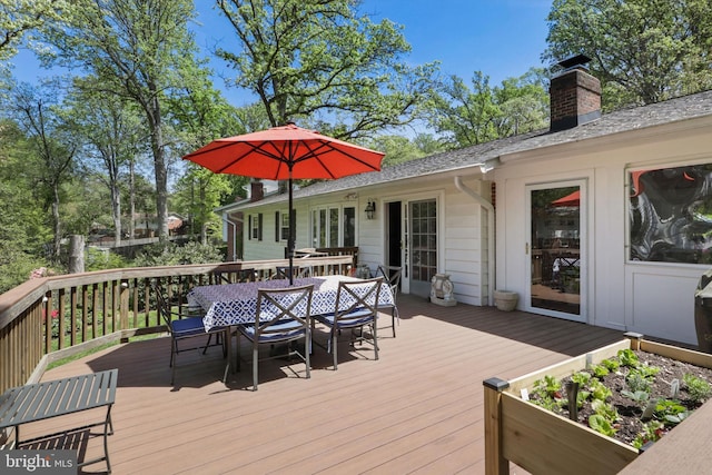 wooden terrace with outdoor dining area and french doors