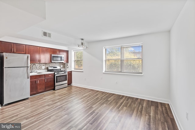 kitchen featuring decorative backsplash, stainless steel appliances, light hardwood / wood-style flooring, and sink