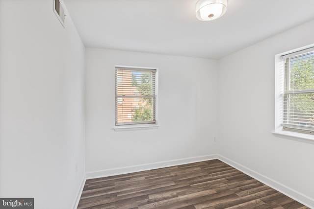 unfurnished room with dark hardwood / wood-style flooring and a healthy amount of sunlight