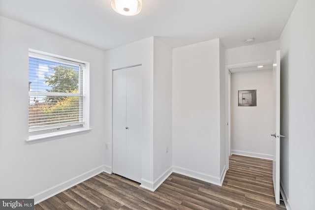 unfurnished bedroom featuring dark hardwood / wood-style flooring and a closet