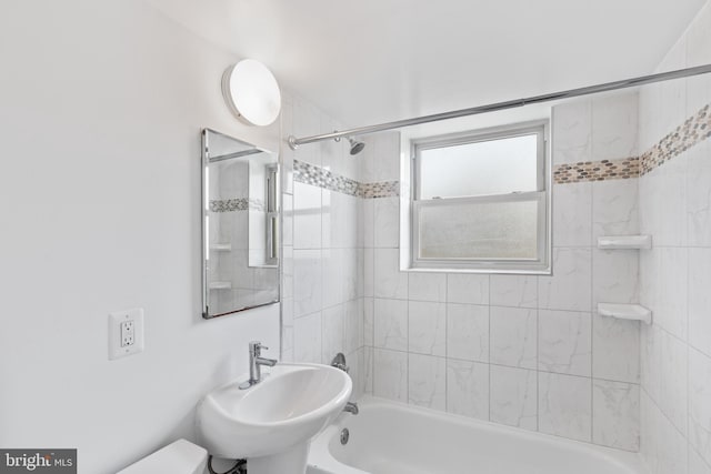 full bathroom with toilet, sink, and tiled shower / bath