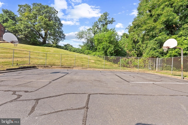 exterior space with a lawn and basketball court