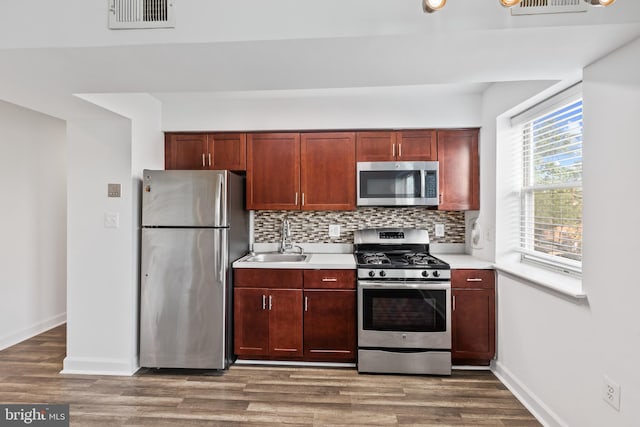 kitchen featuring decorative backsplash, stainless steel appliances, a healthy amount of sunlight, and sink