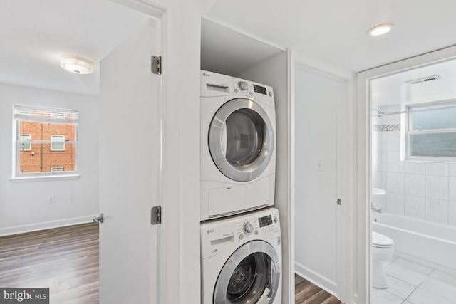 clothes washing area with stacked washer and clothes dryer