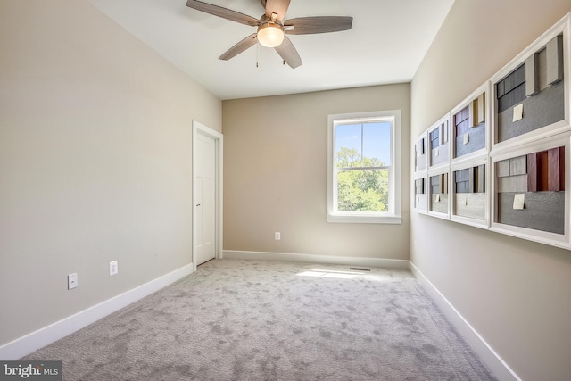 carpeted spare room featuring ceiling fan