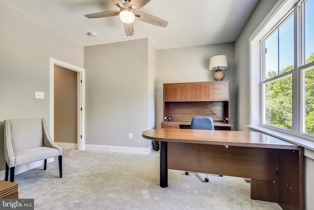 carpeted home office featuring ceiling fan