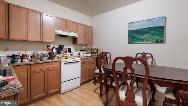 kitchen with white electric stove, light hardwood / wood-style floors, and light stone countertops