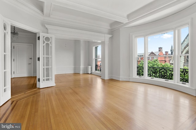 empty room with radiator, beam ceiling, light hardwood / wood-style floors, and crown molding