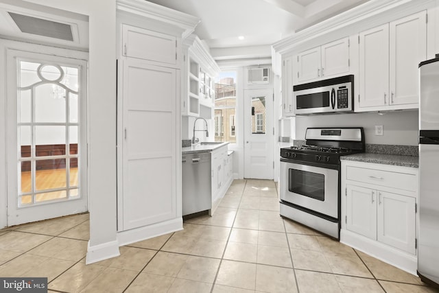 kitchen with white cabinets, stainless steel appliances, and light tile flooring