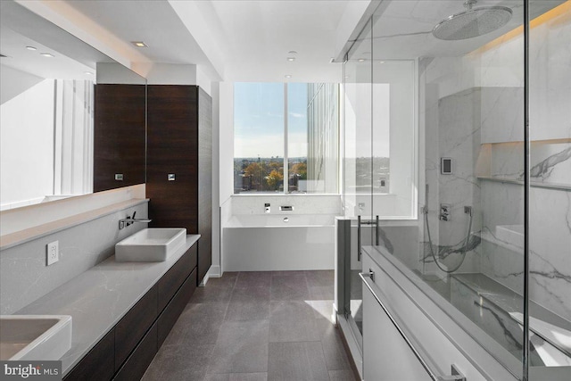 bathroom with tile flooring, independent shower and bath, and double sink vanity