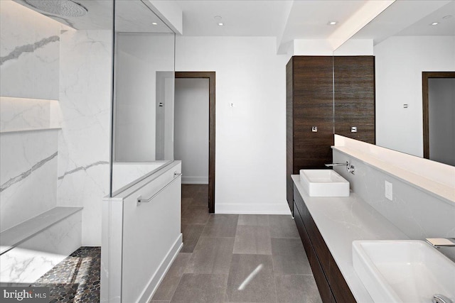 bathroom featuring tile walls, oversized vanity, double sink, and tile flooring