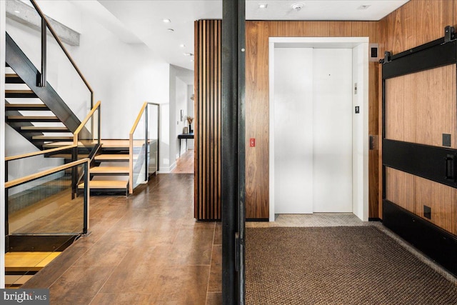 corridor featuring hardwood / wood-style floors, elevator, and a barn door