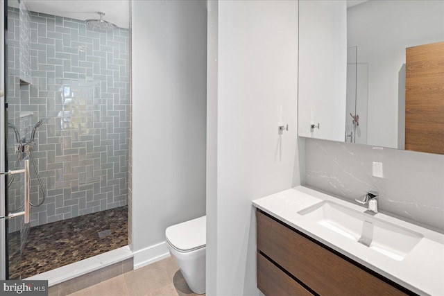 bathroom with oversized vanity, tile floors, toilet, and tiled shower