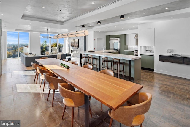 dining space featuring a wall of windows and a tray ceiling