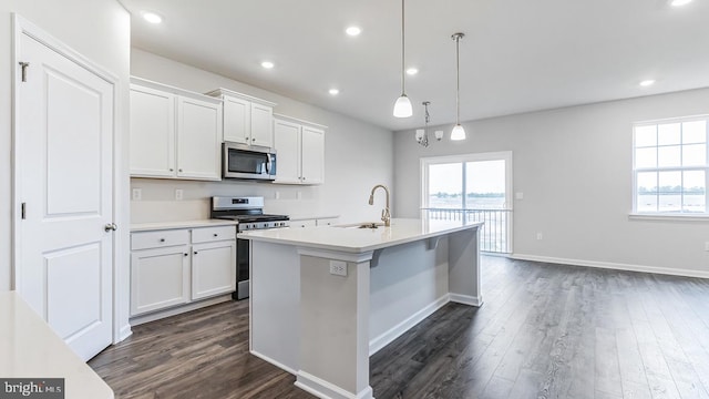 kitchen featuring white cabinets, decorative light fixtures, sink, and appliances with stainless steel finishes