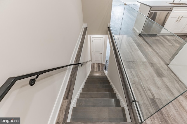 stairs with wood-type flooring and a high ceiling