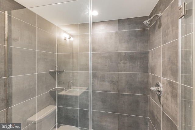 bathroom with toilet and a tile shower