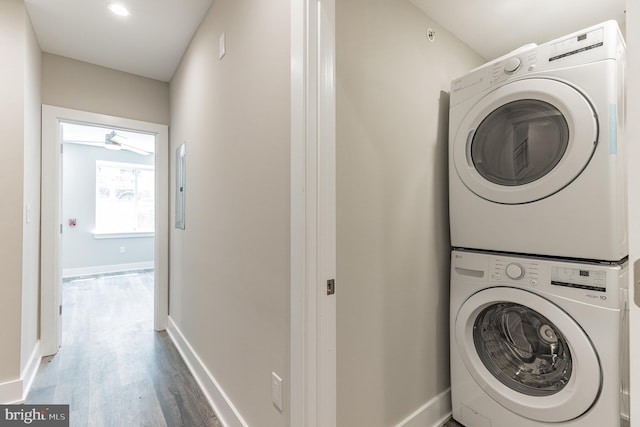 washroom with hardwood / wood-style flooring and stacked washer and clothes dryer