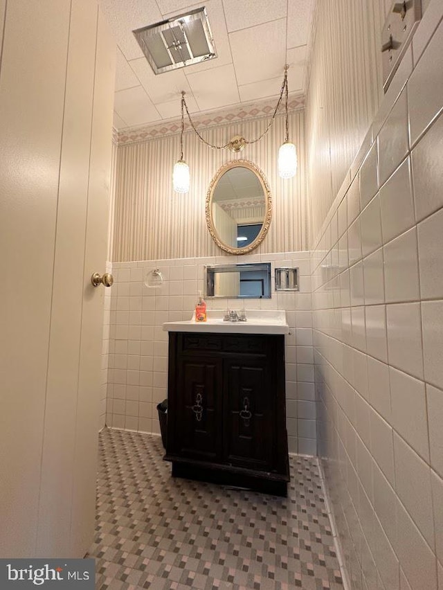 bathroom with tile walls, vanity, and tile floors