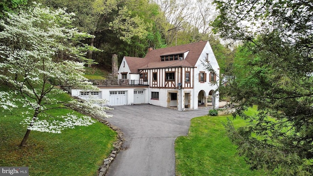 english style home with a garage and a front yard