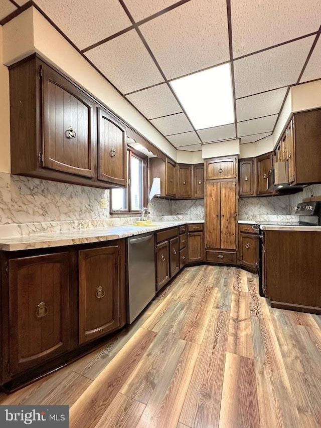 kitchen with tasteful backsplash, dishwasher, a paneled ceiling, and light wood-type flooring