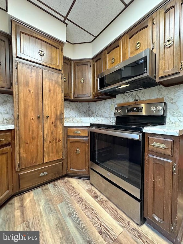 kitchen featuring light hardwood / wood-style flooring, backsplash, and stainless steel appliances