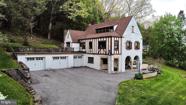 tudor home with a garage and a front yard