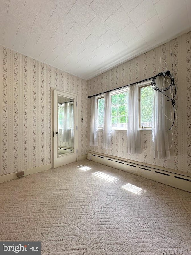 carpeted spare room with baseboard heating