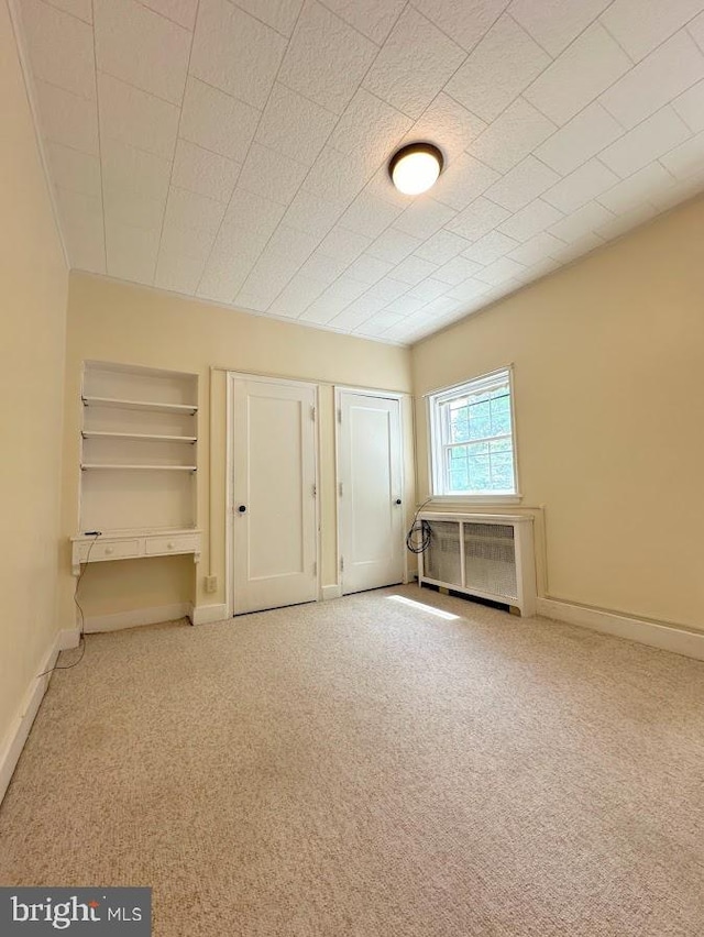 interior space with carpet floors and radiator