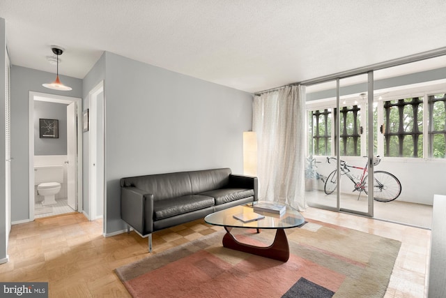 living room with light parquet flooring and a textured ceiling