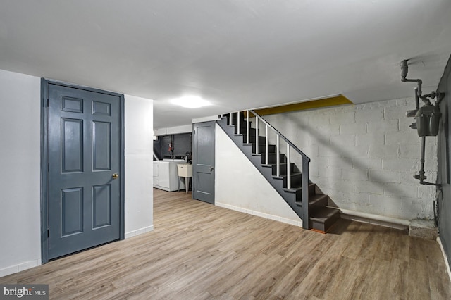 foyer entrance featuring washer / dryer, light hardwood / wood-style floors, and sink