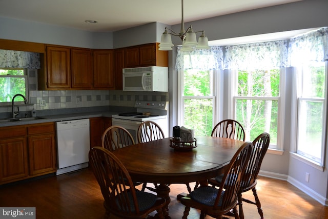 dining space featuring a notable chandelier, sink, and light wood-type flooring