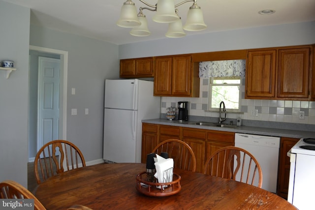 kitchen featuring tasteful backsplash, white appliances, decorative light fixtures, an inviting chandelier, and sink