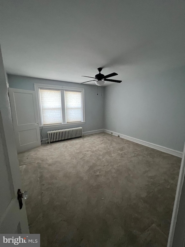 unfurnished room with ceiling fan, radiator heating unit, and carpet floors