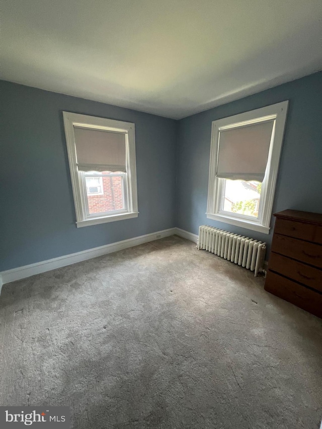 carpeted empty room with radiator