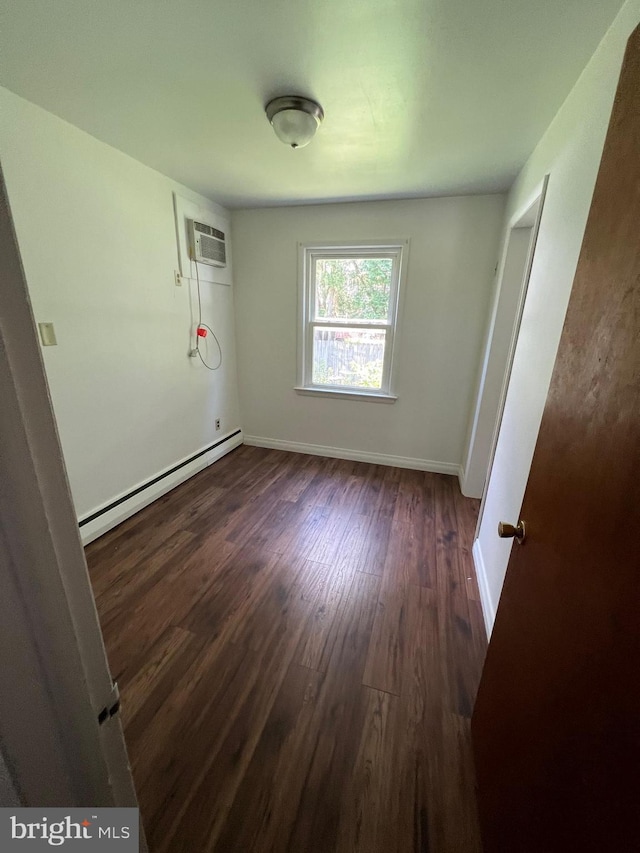 unfurnished room with dark hardwood / wood-style floors, a baseboard radiator, and a wall mounted AC