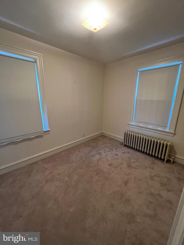 carpeted spare room featuring radiator