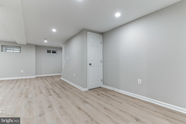 basement with light hardwood / wood-style flooring