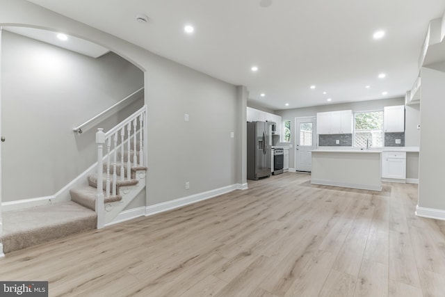 unfurnished living room featuring sink and light wood-type flooring