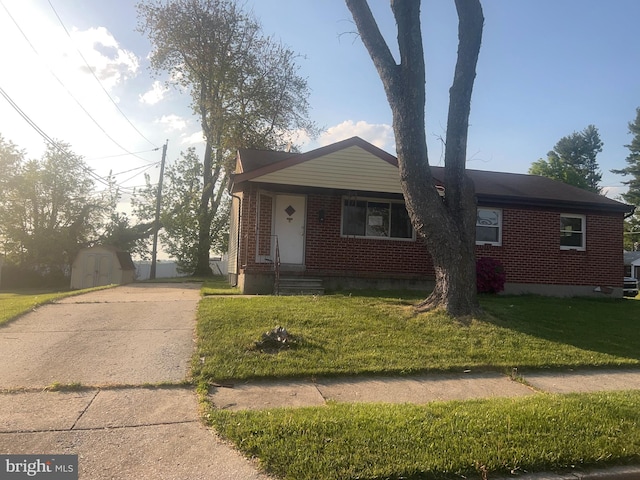 view of front of home with a front yard and a storage unit