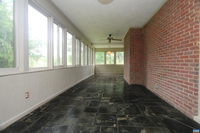 unfurnished sunroom featuring ceiling fan