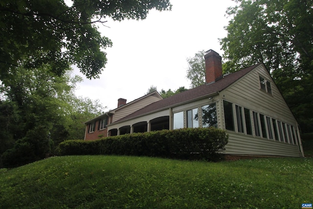 view of side of property with a lawn