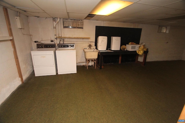 basement featuring washing machine and dryer, a drop ceiling, sink, and dark colored carpet