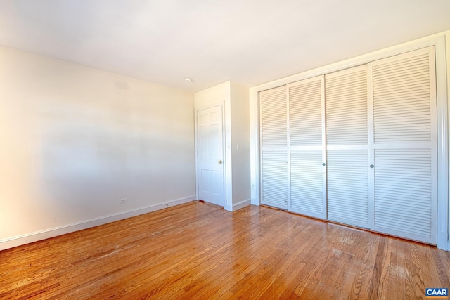 unfurnished bedroom with a closet and light wood-type flooring