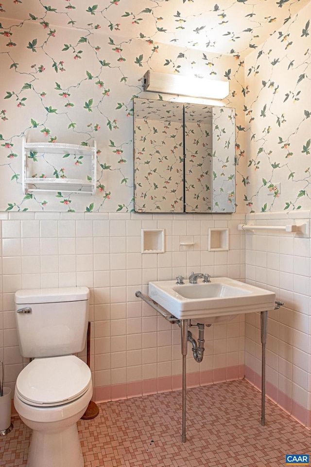 bathroom featuring toilet and tile walls