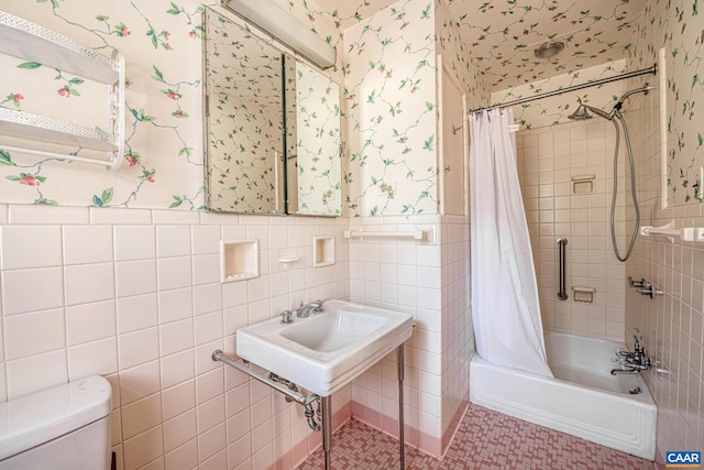 bathroom featuring shower / bath combo with shower curtain, tile patterned flooring, toilet, and tile walls